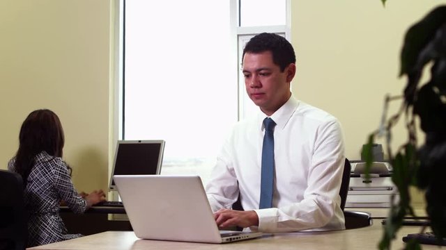 A business man works on his laptop at his desk