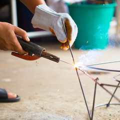 worker use electric welding connecting construction metal