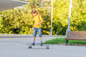young boy skateboarding on natural background