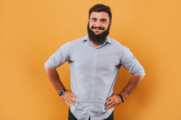 portrait of handsome smiling man isolated on yellow studio background posing to the camera and making funny faces