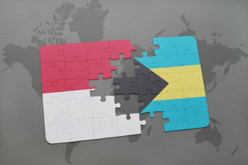 puzzle with the national flag of indonesia and bahamas on a world map background.