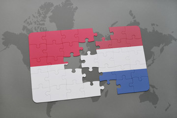 puzzle with the national flag of indonesia and netherlands on a world map background.