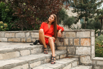 Fototapeta na wymiar girl in red dress in the garden on steps