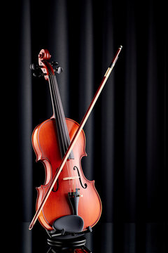 Close up of a violin on glass surface and black background