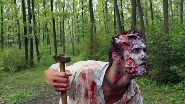 crazy scary zombie standing in the woods and looking for the victim