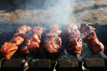 Grilling marinated shashlik preparing on a barbecue grill over charcoal