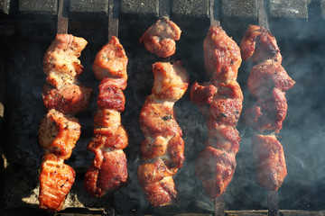 Grilling marinated shashlik preparing on a barbecue grill over charcoal