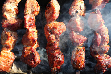 Grilling marinated shashlik preparing on a barbecue grill over charcoal