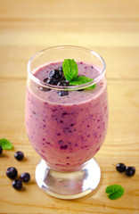 Healthy blueberry banana smoothie with mint and fresh berries in a glass