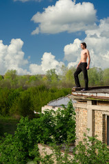 Brave adventures man standing on roof edge of old building