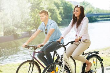 Smiling Couple On Bicycle In The Park