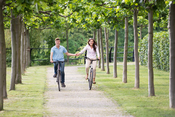 The Happy Couple Cycling In Park