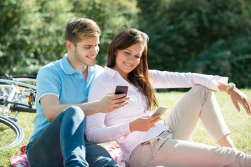 Happy Young Couple Using Mobile Phone
