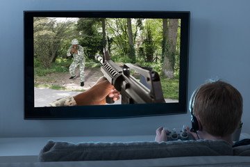 Boy Playing Action Game On Television