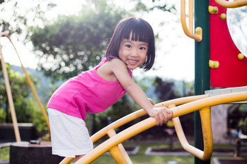 Fototapeta na wymiar Asian Chinese little girl climbing at playground
