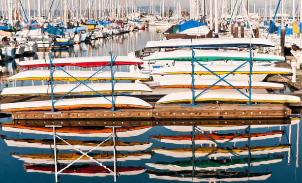 Colorful Kayaks Stacked on a Pier at a Marina north of Seattle and Reflected in the Water