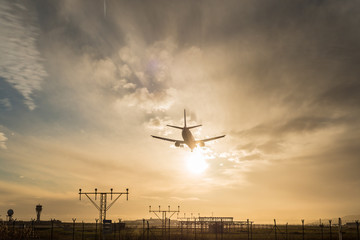 Fototapeta na wymiar Airplane landing at dusk.