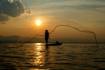 Fisherman , Silhouette fisherman with net at the lake in Thailand (kwan phayao) Phayao.-May 14,2016