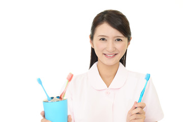 歯ブラシを持つ笑顔の歯科衛生士