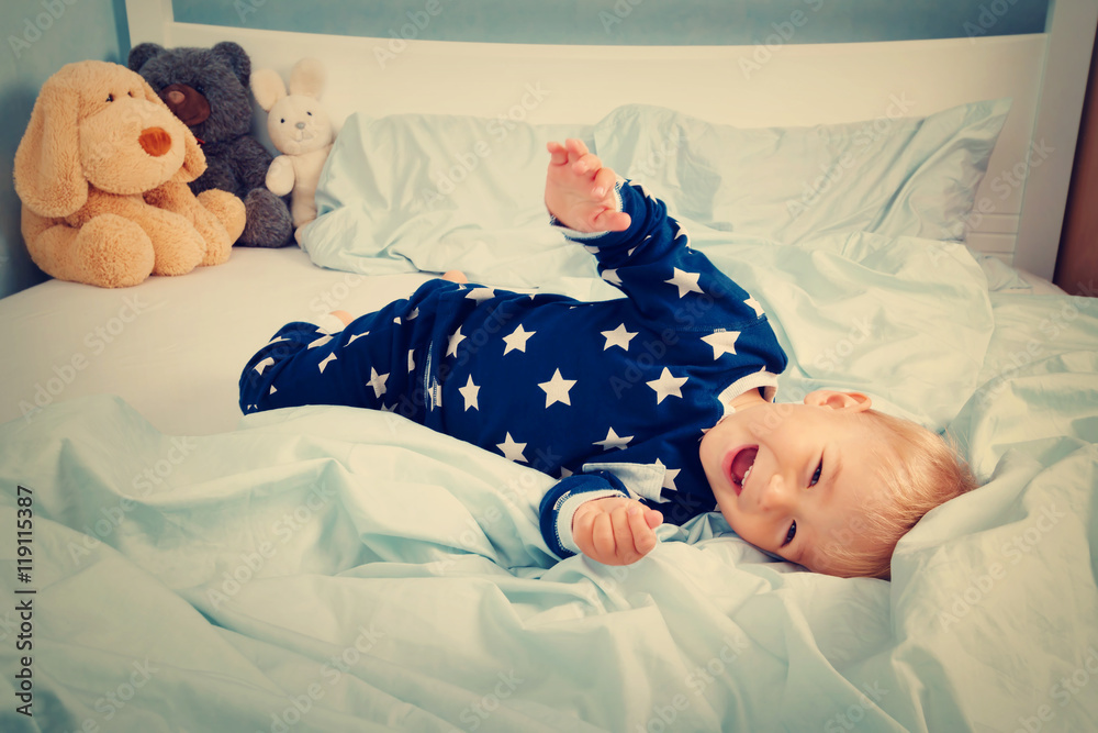 Wall mural One year old baby in the bed