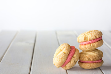 Stack of Raspberry Melting Moments on White Wooden Table with Copy Space Horizontal