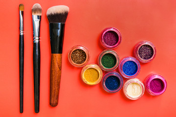 Various makeup products on red background