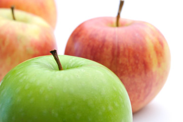 different concepts - green apple between red apples