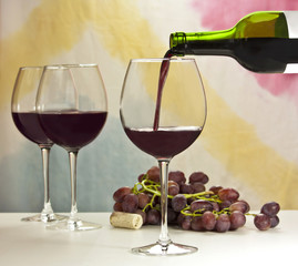 Photo of red wine poured into glass from bottle