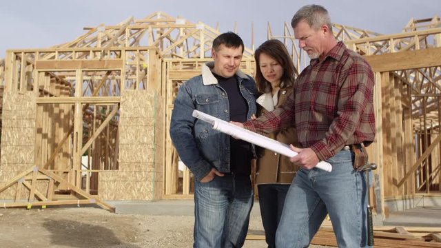 Couple speaking to contractor about floor plan