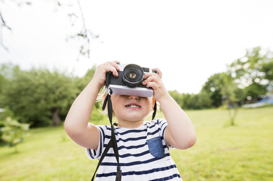 Little girl in park playing with camera