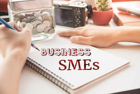 Businessman write SME word on book (small business concept)