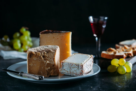 Closeup of cheese on plate and a red wine