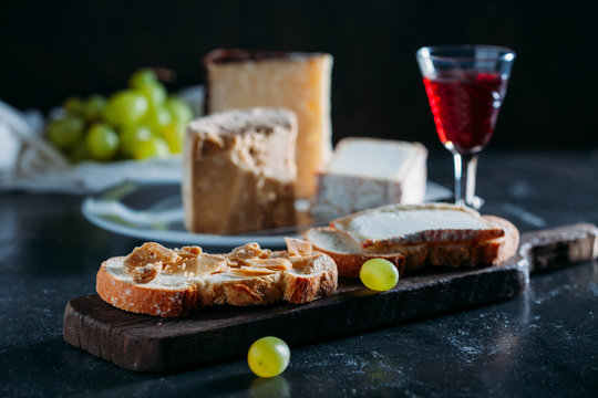 Closeup of cheese on plate and a red wine