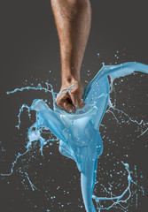 Close-up of a man's fist punching through liquid