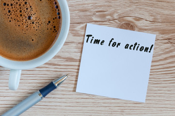 TIME FOR ACTION writting on paper near cup of morning coffee at workplace or wooden table