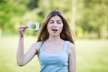 Young girl with a cardboard symbol of camera