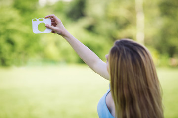 Young girl with a cardboard symbol of camera
