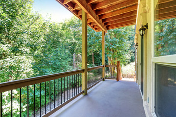 Covered deck with railings and forest landscape