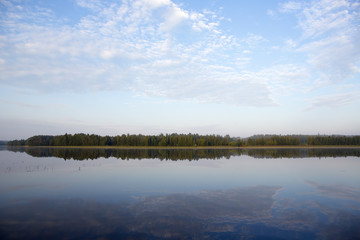 Cold morning. An image of landscape shot taken from the shore during sunrise from the back. Some mist is visible.