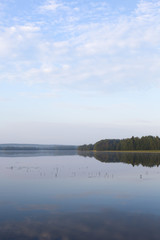 Cold morning. An image of landscape shot taken from the shore during sunrise from the back. Some mist is visible.