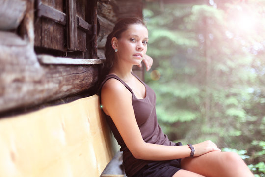 junge Frau ruht sich auf der Bank vor der Hütte aus