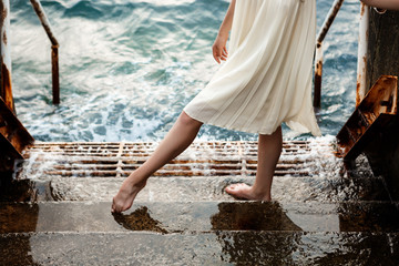 Young beautiful ballerina dancing and posing outside, sea background.