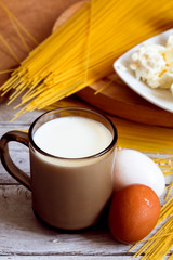 cooking spaghetti on a wooden background milk eggs
