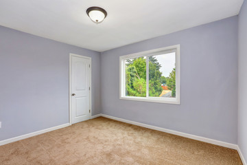 Empty room interior with lavender walls and beige carpet.