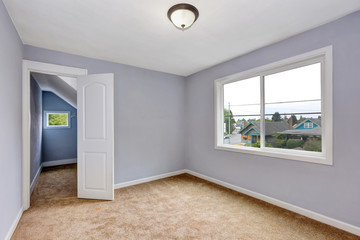 Empty room interior with lavender walls and beige carpet.