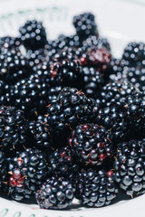 Macro of delicious and fresh blackberries on plate.Bokeh