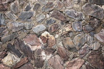 real medieval stone wall surface can use as background pattern or texture with real light at old town Songkhla Thailand (vintage style)
