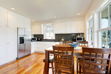Design of kitchen room interior with white cabinets and black counter tops
