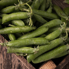 pods of green peas on a wooden table, rustic style,healthy food