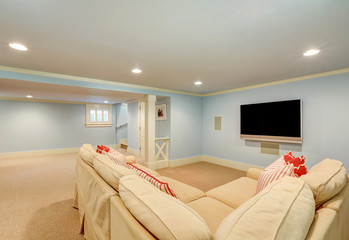Spacious basement living room interior in pastel blue tones